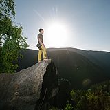 Eine Person steht auf einem großen Felsen 