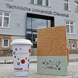 Notebook und Becher vor dem Hauptgebäude der TU Clausthal